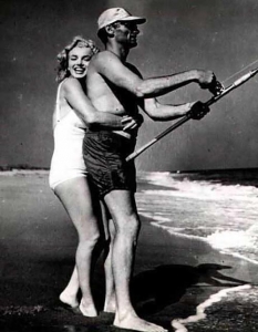 Arthur Miller pescando mientras Marilyn Monroe lo abraza