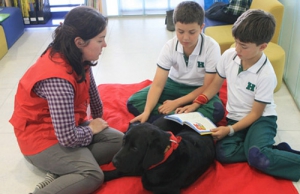 Niños leyendo con un perro adiestrado