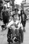 Hombre en silla leyendo mientras lo pasean por las calles de Nueva York