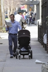 Hombre con coche de bebé leyendo en Nueva York